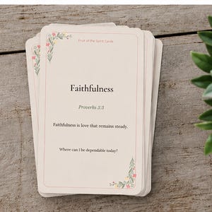 May include: A stack of cream-colored cards with rounded corners, featuring the text Fruit of the Spirit Cards, Faithfulness, Proverbs 3:3, Faithfulness is love that remains steady, and Where can I be dependable today, accented with small floral illustrations.