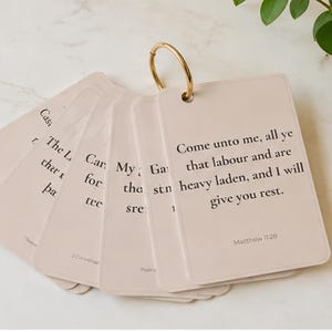 May include: A set of light beige rectangular cards held together by a gold metal ring. Each card features black printed text with biblical verses, including the visible text: Come unto me, all ye that labour and are heavy laden, and I will give you rest. Matthew 11:28.