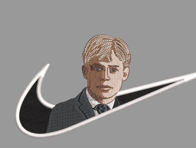 Pu&ograve; includere: Design ricamato con un ritratto di un uomo in giacca e cravatta, integrato in un logo swoosh bianco e nero. L'uomo ha i capelli castano chiaro e indossa un abito scuro con cravatta nera. Lo sfondo &egrave; grigio.