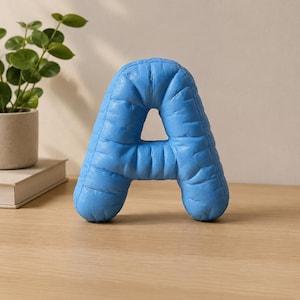 Close-up view of 3D rounded puffy letter STL models for 3D printing. Digital files shown as a colorless mesh to illustrate the 3D printable structure and smooth surface finish.