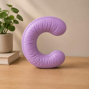 Close-up view of 3D rounded puffy letter STL models for 3D printing. Digital files shown as a colorless mesh to illustrate the 3D printable structure and smooth surface finish.