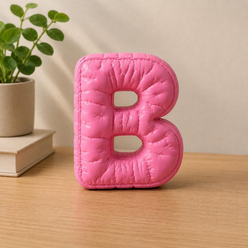 Close-up view of 3D rounded puffy letter STL models for 3D printing. Digital files shown as a colorless mesh to illustrate the 3D printable structure and smooth surface finish.