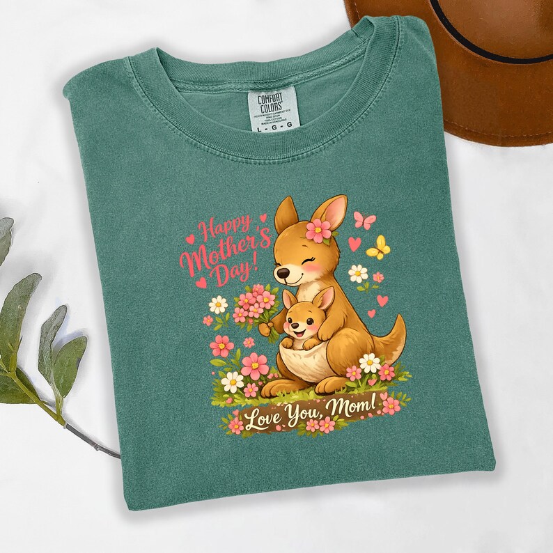 May include: Green Comfort Colors t-shirt featuring a cartoon kangaroo and joey with flowers. Text reads "Happy Mother's Day! Love You, Mom!" The design includes pink hearts and butterflies. The shirt is a size L-G-G.