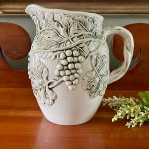 May include: A set of three ceramic mugs with a speckled, matte finish. The mugs are in shades of cream, light gray, and dark gray. Each mug has a simple, minimalist design and a rounded handle. Perfect for coffee or tea.