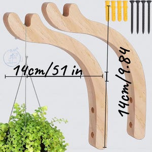 Könnte beinhalten: Zwei hellbraune Pflanzenhalter aus Holz mit geschwungenem Design, jeweils 14 cm hoch. Die Halterungen werden mit Montagematerial geliefert. Der Text auf dem Bild lautet "14cm/51 in". Eine Hängepflanze ist zu sehen.