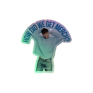 May include: A holographic sticker featuring a person in a light blue sweatshirt and jeans. The sticker has the text "HOW DID WE GET MERCH?" in a curved design above the person's head. The Rolling Stone logo is visible on the jeans.