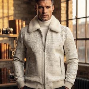 May include: A white jacket with a textured crocodile skin pattern, featuring a plush white faux fur collar, a central silver zipper, and ribbed cuffs. The jacket is worn over a white turtleneck sweater, creating a layered look with a clean aesthetic.