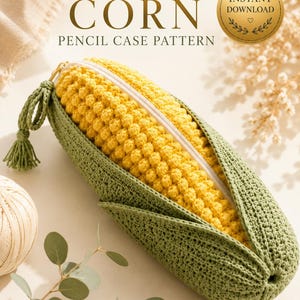 Puede incluir: Un estuche de ganchillo con forma de mazorca de maíz con granos amarillos y hojas verdes. El texto dice CROCHET CORN PENCIL CASE PATTERN e INSTANT DOWNLOAD. Cuenta con una cremallera blanca y una borla verde unida al tirador.