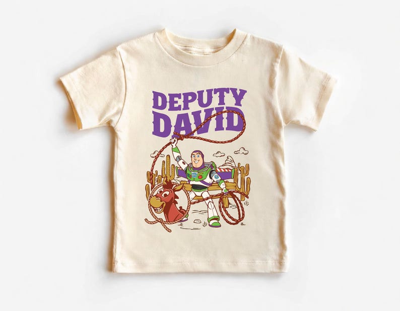 Personalized Sheriff Shirt, Custom Deputy Name T-Shirt, Space Ranger Cowboy Tee, Kids Western Birthday Gift, Toddler Buzz Lightyear Shirt

Step into an adventure-filled world for your little hero! This custom-designed t-shirt blends a beloved space-themed character with a fun western twist, sparking your child's imagination. It is the perfect outfit for birthday parties and a stylish choice for everyday playtime.