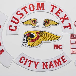 Puede incluir: Un conjunto de parches bordados con temática motera. Los parches presentan una calavera alada, el texto "CUSTOM TEXT", "CITY NAME", "HELLS ANGELS", "AFFA", "666", "NOMADS" y "1%", en rojo sobre fondo blanco.