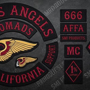 May include: Embroidered patches in red and black, including "HELLS ANGELS NOMADS CALIFORNIA", a winged skull, and other patches with text and symbols. Features the number "1" and the letters "MC".