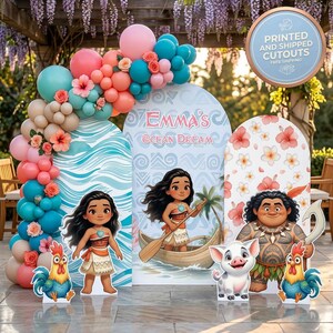 May include: A party decoration set featuring three arched backdrops with wave, tribal, and floral patterns, including cutouts of a girl in a boat, a man with tattoos, a pig, and two roosters, accented by a large balloon garland in pink, teal, and tan.