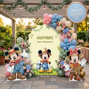 May include: A party backdrop featuring the text 'OLIVER'S Farm Adventure' with Mickey and Minnie Mouse cutouts wearing straw hats and farm clothing, surrounded by a balloon arch in shades of blue, pink, and beige with floral accents.