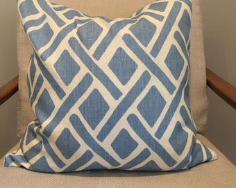 May include: A blue and white patterned throw pillow with a geometric design. The pillow is made of a soft, textured fabric.