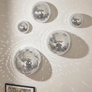 Op de afbeelding: Een witte keramische mok met een zwart handvat en de tekst "But First, Coffee" in handschriftstijl. De mok staat op een wit oppervlak. De mok is ongeveer 10 cm hoog.