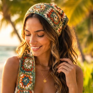 May include: A colorful crochet headband and scarf set. The headband features a square pattern in shades of green, orange, and cream. The scarf hangs down the front, also with a square pattern. A gold necklace with a pendant is also visible.