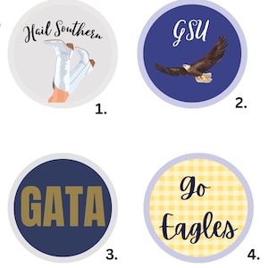 May include: Four circular buttons labeled GA Southern Buttons. Button 1 is light gray with white boots and the text Hail Southern. Button 2 is blue with a flying eagle and GSU. Button 3 is dark blue with gold GATA text. Button 4 is yellow plaid with Go Eagles.