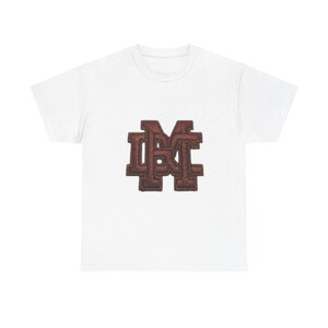 Könnte beinhalten: Weißes T-Shirt mit einem braunen, detaillierten Emblem. Das Emblem ist wahrscheinlich ein Monogramm oder Logo, möglicherweise für Initialen oder eine Marke. Das T-Shirt hat einen klassischen Rundhalsausschnitt.