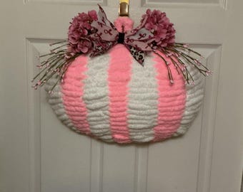 Ghirlanda di zucche a righe rosa e bianche, decorazione autunnale per la sensibilizzazione sul tema del seno.