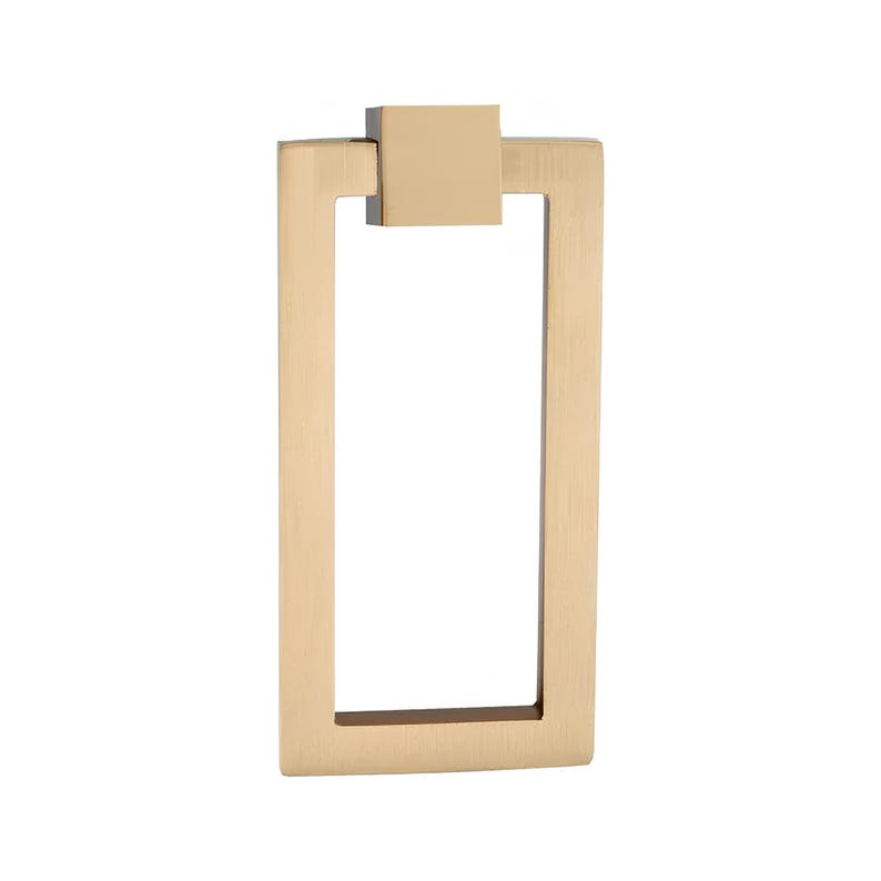 Puede incluir: Un tirador de armario rectangular de color dorado con un detalle cuadrado en la parte superior. El tirador tiene un dise&ntilde;o sencillo y moderno, con un asa rectangular y una placa de montaje cuadrada. La ferreter&iacute;a es de metal y tiene un acabado cepillado.