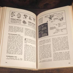 May include: An open hardcover book displaying pages 204 and 205, featuring technical text and black-and-white line drawings of electrical wiring diagrams, pendant switches, and canopy switches with detailed instructional labels and circuit schematics.