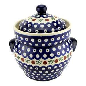 May include: A ceramic jar with a lid, featuring a cream-colored base decorated with a repeating pattern of dark blue circles with white centers, interspersed with small red dots and green star-like accents, complete with two side handles.