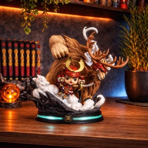 Könnte beinhalten: Detaillierte Figur eines Charakters in Samurai-Rüstung, der auf einem großen, gehörnten Tier reitet. Die Figur hat ein rot-goldenes Farbschema, mit einer Basis, die ein blau-grünes Leuchten aussendet. Der Hintergrund umfasst Bücher und eine Topfpflanze.