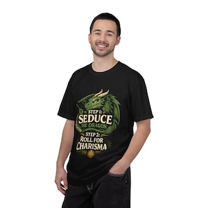 May include: Black t-shirt with a green dragon graphic and the text "Step 1: Seduce the Dragon, Step 2: Roll for Charisma". The design features a green dragon with yellow eyes. The shirt is made of a soft material.