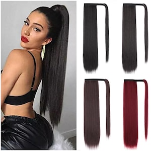 Può includere: Una donna con lunghi capelli scuri raccolti in una coda di cavallo alta. L'immagine mostra anche quattro extension per capelli a coda di cavallo in nero, marrone scuro, marrone medio e bordeaux. Queste extension sono progettate per essere avvolte attorno alla coda di cavallo naturale.