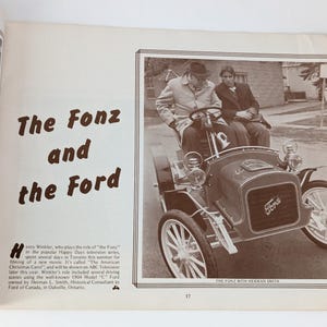 May include: A black and white photo of Henry Winkler, known as "The Fonz" from the TV show "Happy Days", sitting in a vintage 1904 Model "C" Ford. The caption reads "The Fonz with Herman Smith".