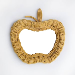 May include: A wicker apple-shaped mirror with a natural woven finish.