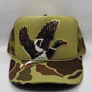 May include: A set of three ceramic mugs with a speckled, matte finish. The mugs are in shades of cream, light gray, and dark gray. Each mug has a simple, minimalist design and a rounded handle.