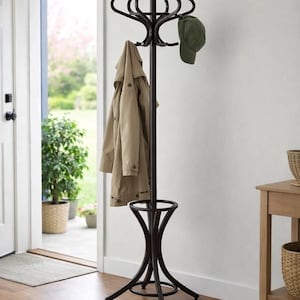 May include: A dark brown metal coat rack with multiple curved hooks at the top. A tan coat and a green baseball cap hang from the hooks. The rack has a circular base and a decorative support.