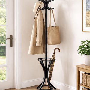 May include: A black metal coat rack with multiple hooks for hanging coats, hats, and bags. A tan trench coat, a beige tote bag, and a straw hat hang from the hooks. An umbrella rests in the base of the rack. The rack is in a home entryway.