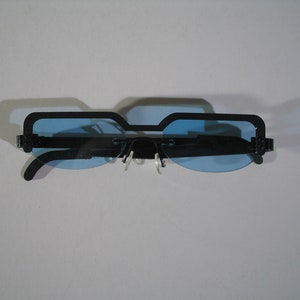 May include: Black framed sunglasses with blue lenses. The sunglasses have a rectangular shape.
