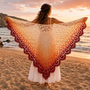 Pode incluir: Um xale triangular de crochê com um gradiente de cores que transita de um centro creme para uma borda festonada em vermelho escuro. O padrão de renda intrincado exibe um design delicado e vazado, apresentando uma forma ampla e extensa.