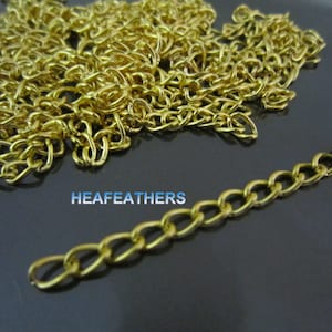 May include: A close-up of a gold chain, with a small section of the chain laid out straight. The chain is made of small, linked ovals. The text "HEAFEATHERS" is visible in the image.