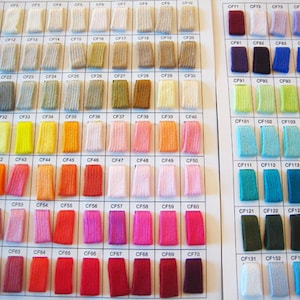 Könnte beinhalten: Eine Farbkarte mit 135 Stoffmustern, die jeweils mit einem Code gekennzeichnet sind. Die Muster sind in Reihen und Spalten angeordnet, und die Farben reichen von Weiß bis Schwarz, mit vielen Zwischentönen.