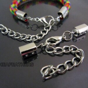 May include: A silver chain bracelet with a colorful braided cord and silver clasp. The bracelet comes with two extra chain extensions with silver end caps.