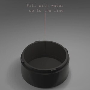 May include: A black, cylindrical container with a wide opening. The text "Fill with water up to the line" is displayed above the container, with a pink line indicating the fill level. The container is set against a gray background.