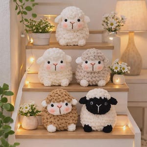 May include: Five plush sheep toys made of chunky yarn, arranged on wooden stairs. The sheep feature round bodies, small ears, black button eyes, and pink blush on their cheeks. They come in white, beige, and one with a black head and white body.