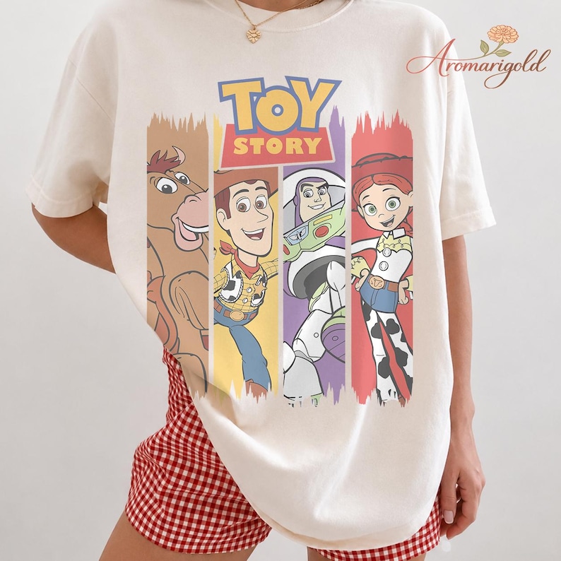 Puede incluir: Camiseta color crema con el logo y los personajes de Toy Story. El dise&ntilde;o incluye a Woody, Buzz Lightyear, Jessie y Bullseye, cada uno en un bloque de color vertical. La camiseta es de corte holgado.