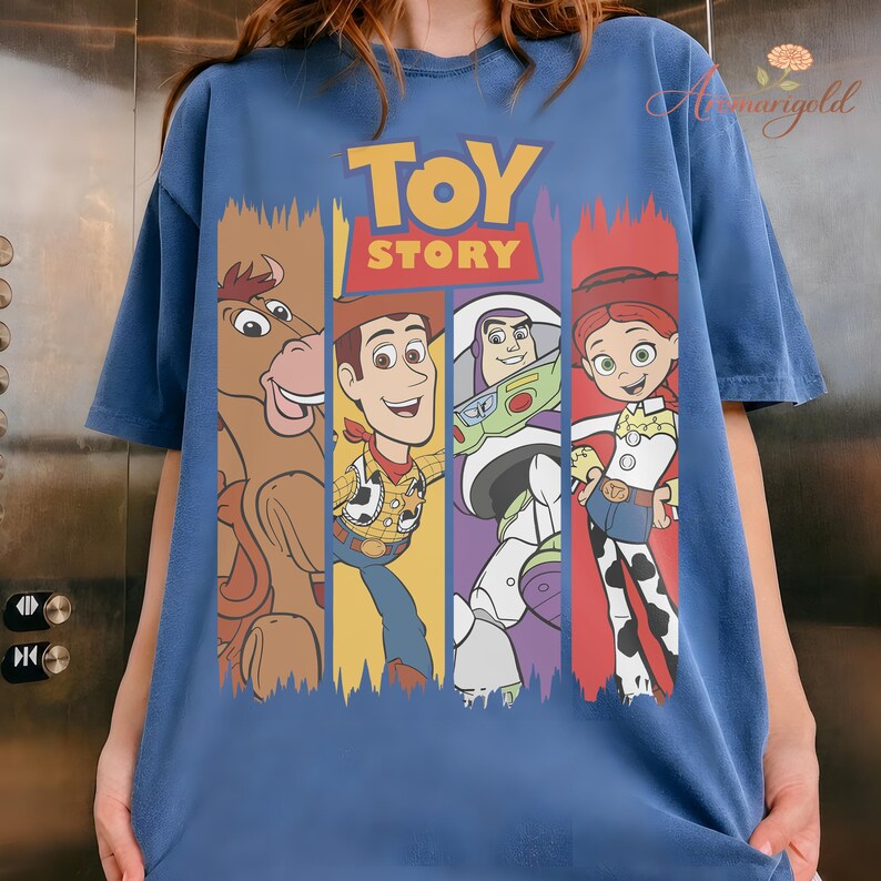 Puede incluir: Camiseta azul con la inscripci&oacute;n "TOY STORY" y personajes de dibujos animados. Los personajes incluyen un caballo, Woody, Buzz Lightyear y Jessie. La camiseta es de color azul liso.