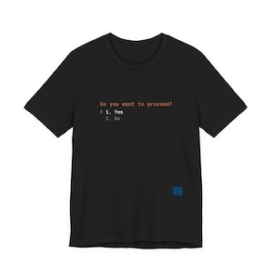 Peut inclure: T-shirt noir avec le texte orange "Do you want to proceed ?" et les options 1. Oui et 2. Non. Un petit carré bleu est visible en bas à droite du t-shirt.
