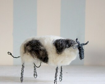 Wired cow with white and dark wool
