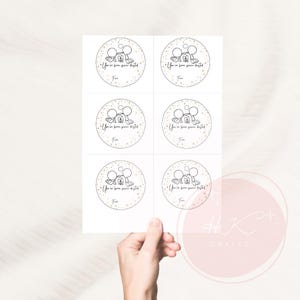 Op de afbeelding: Een vel witte cirkelvormige stickers met een cartoon muis ontwerp. Elke sticker heeft de tekst "You've been pixie dusted" en "Fun" in een handschrift stijl lettertype. De stickers zijn omringd door gouden sterren.
