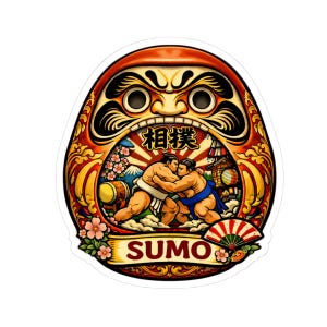 May include: A colorful sticker featuring a Daruma doll design with a sumo wrestling scene inside. The sticker has a red and gold color scheme, with the word "SUMO" in a banner at the bottom. The Japanese characters for sumo are also present.