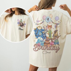 K&ouml;nnte beinhalten: Cremefarbenes T-Shirt mit einem Cartoon-Faultier mit Partyhut und dem Namen "Mark". Auf der R&uuml;ckseite des Shirts befindet sich ein "Birthday Crew"-Design mit verschiedenen Cartoon-Figuren, Luftballons und einer Torte.