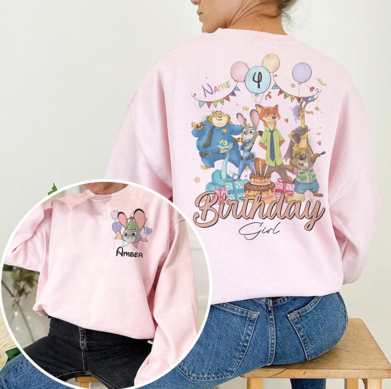 K&ouml;nnte beinhalten: Hellrosa Sweatshirt mit einem Cartoon-Motiv von Figuren, Luftballons und den Worten "Birthday Girl". Das Design enth&auml;lt die Zahl 4 und den Namen "Name" &uuml;ber den Figuren. Ein kleineres Bild auf der Vorderseite zeigt ein Hasenmotiv und den Namen "Amber".