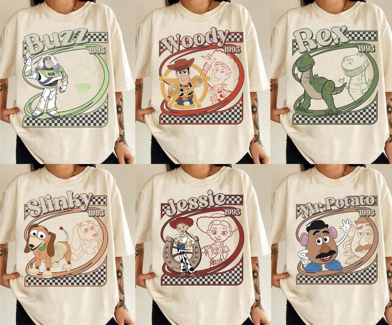 May include: Cream-colored t-shirts featuring various Toy Story characters: Buzz Lightyear, Woody, Rex, Slinky Dog, Jessie, and Mr. Potato Head. Each design includes the character's name and "1995" in a retro-style frame with a checkered border.